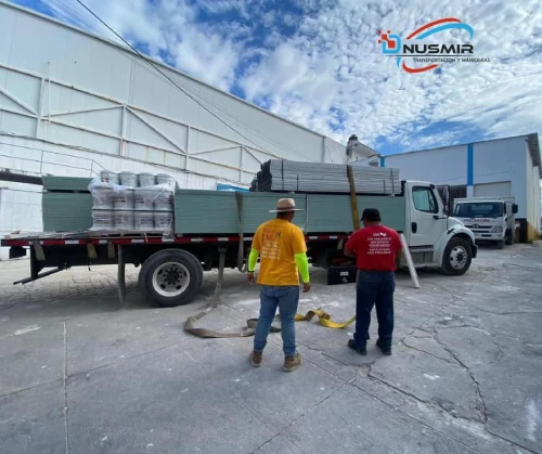 Flete en plataforma con material de construcción asegurado para transporte de carga (Transportes Dnusmir)