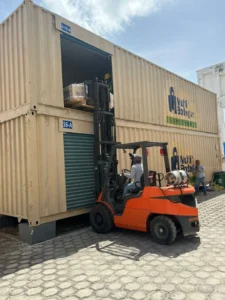 Montacargas realizando carga y descarga de mercancía en contenedor tipo almacén self storage